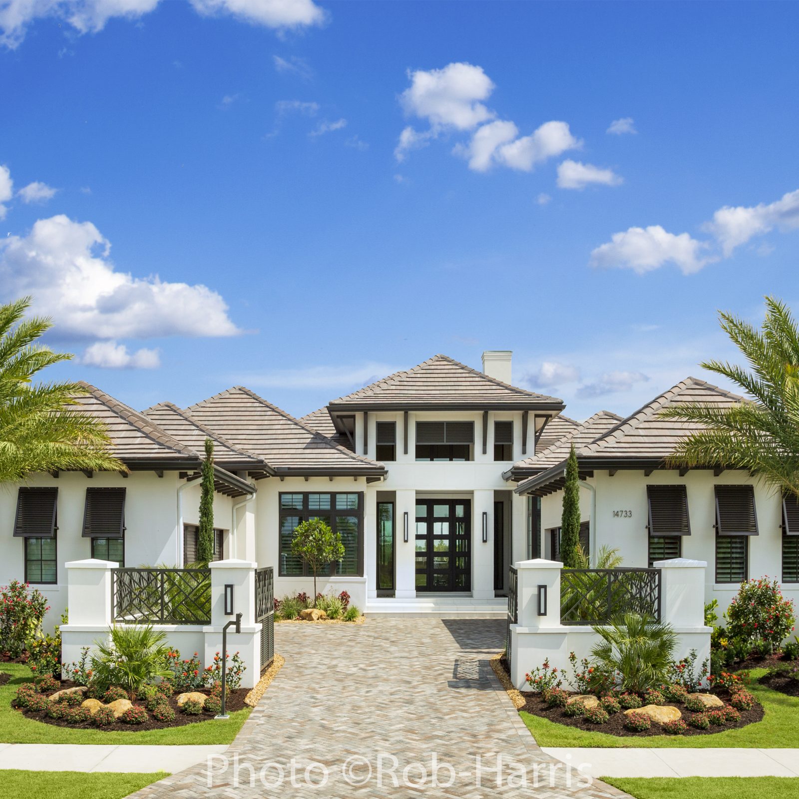 luxury home exterior with palm trees and beautiful landscaping