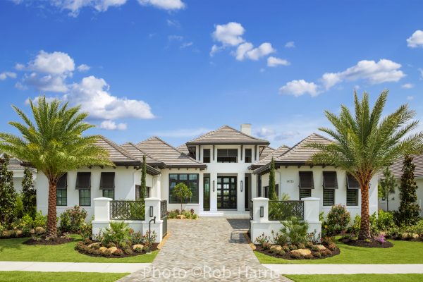 luxury home exterior with palm trees and beautiful landscaping