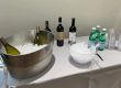 Drinks and an ice bucket on a white clothed table provided by Nancy's Concierge Services Party Planning